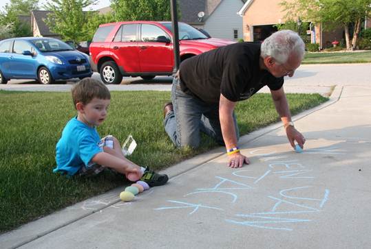 Al and Jack writing in chalk in the driveway