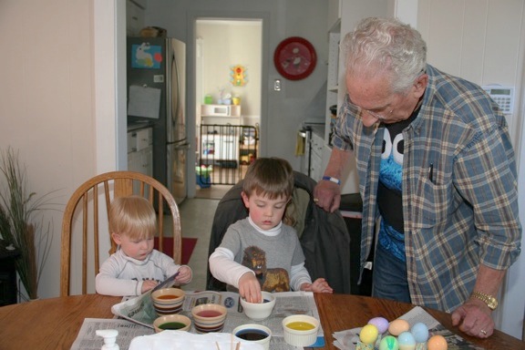 While Jack methodically places an egg into the dye, Owen notices an advertisement for toys in the paper used to protect the table.