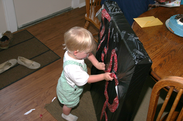 Owen is bored with the re-blowing out candles and decides to start opening the gifts.