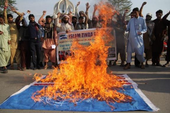 Activists of Ahle Hadees Youth Force shout slogans in front of a burning UN flag protesting against the Nobel Peace Prize laureate Malala Yousafzai, Multan, Dec 11, 2014. (S.S. Mirza/AFP/Getty Images)